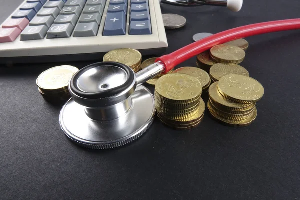 Czerwony stetoskop i monety na czarnym tle. Medyczne — Zdjęcie stockowe