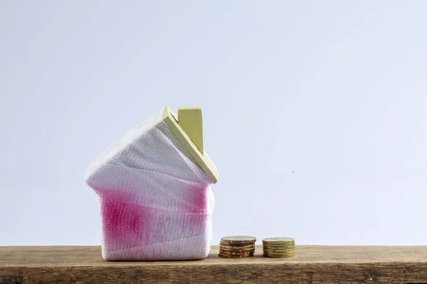 Casa e moedas pequenas. Conceito de poupança de deficiência — Fotografia de Stock