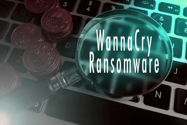 Zvětšení sklo a mince na klávesnici s textem útok ransonware. — Stock fotografie