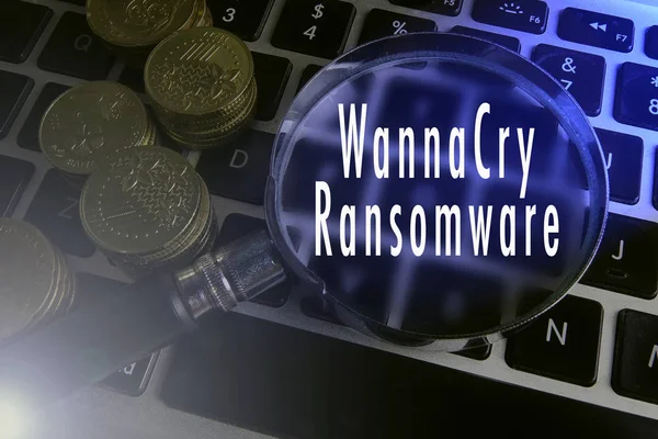 Zvětšení sklo a mince na klávesnici s textem útok ransonware. — Stock fotografie