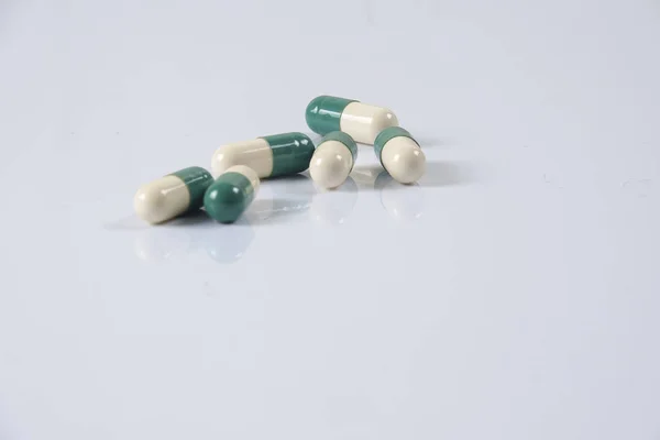 Gelb / grüne Medikamententabletten auf weiß. Gesundheitskonzept — Stockfoto