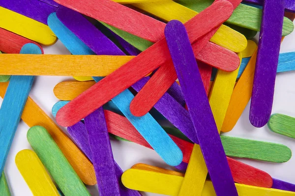 Bunte Holzstäbchen auf weißem Hintergrund — Stockfoto