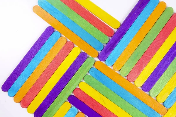 Bunte Holzstäbchen auf weißem Hintergrund — Stockfoto