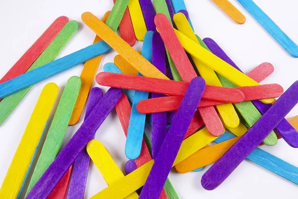 Bunte Holzstäbchen auf weißem Hintergrund — Stockfoto