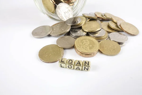 Půjčka slovo na hromadě na zlaté mince nad bílým pozadím. — Stock fotografie