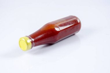 Beyaz arka planda bir şişe kırmızı biber sosu