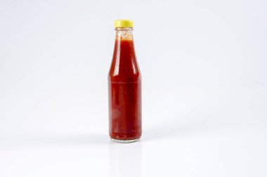 Beyaz arka planda bir şişe kırmızı biber sosu
