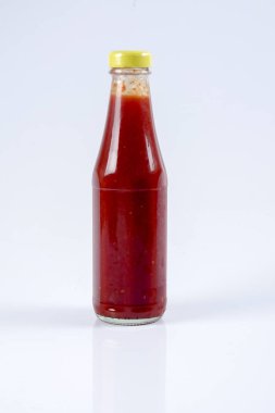 Beyaz arka planda bir şişe kırmızı biber sosu