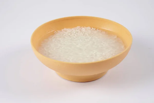 Soak rice in yellow bowl over white background. — Stock Photo, Image