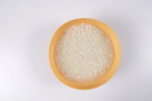 Remoje el arroz en un tazón amarillo sobre fondo blanco . —  Fotos de Stock