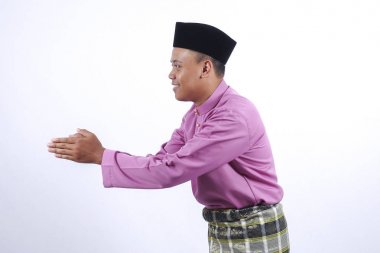 Adam akıllı telefon ile geleneksel giyim Eid Bayramı kutlamak.