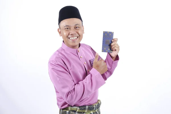 Homem em roupa tradicional alegre com pacote de dinheiro durante comemorar Eid Fitr . — Fotografia de Stock
