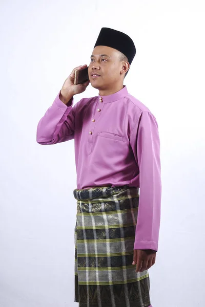 Muž v tradičním oděvu s smartphone slaví Eid Fitr. — Stock fotografie
