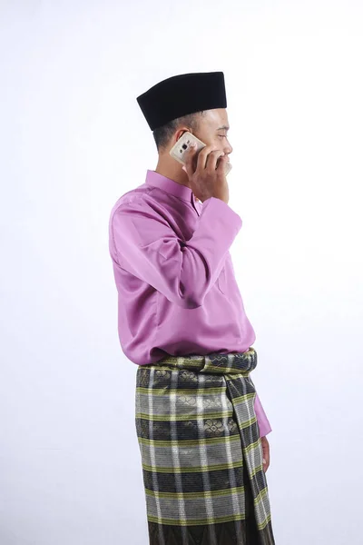Homem em roupas tradicionais com smartphone comemorar Eid Fitr . — Fotografia de Stock