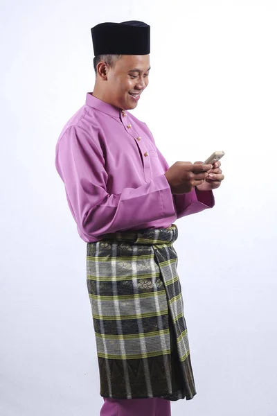 Hombre en ropa tradicional con teléfono inteligente celebrar Eid Fitr . —  Fotos de Stock