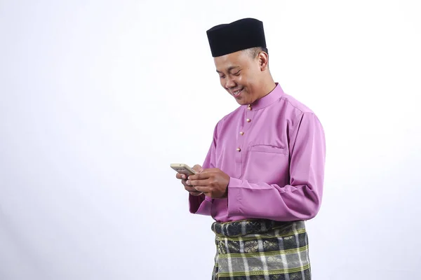 Człowiek w tradycyjne stroje ze smartfonem z okazji Eid al Fitr. — Zdjęcie stockowe
