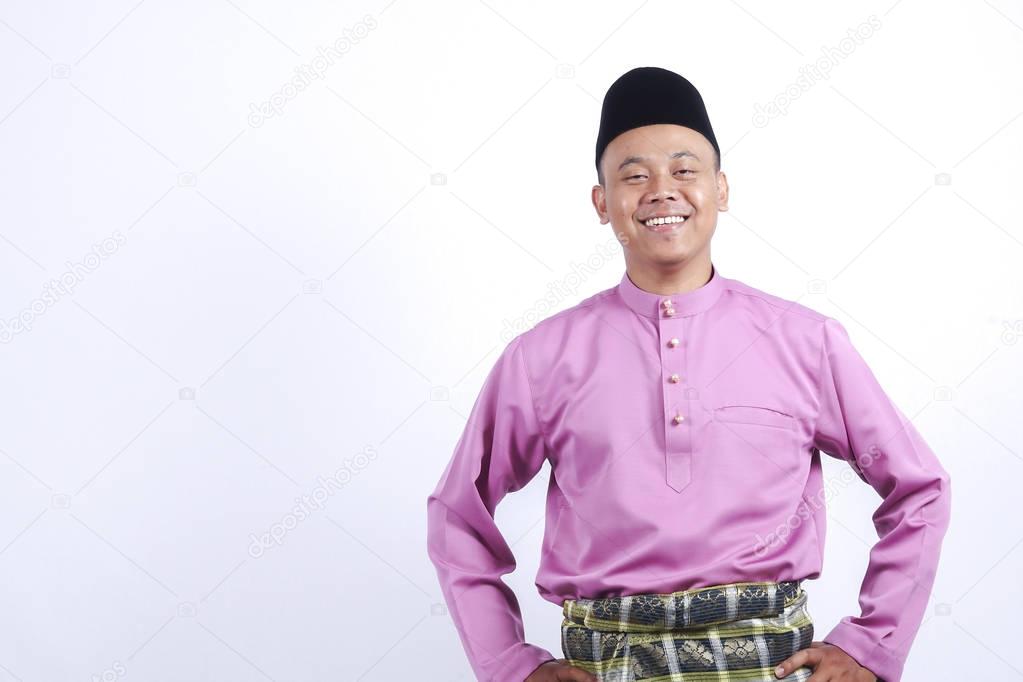 Man in traditional clothing with smartphone celebrate Eid Fitr.
