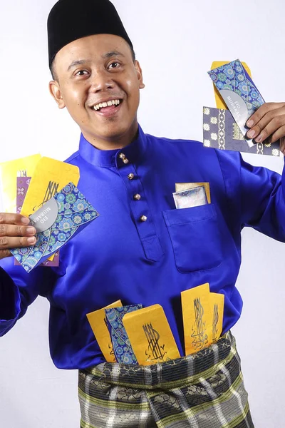 Homem em roupa tradicional alegre com pacote de dinheiro durante comemorar Eid Fitr . — Fotografia de Stock