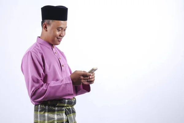 Muž v tradičním oděvu s smartphone slaví Eid Fitr. — Stock fotografie