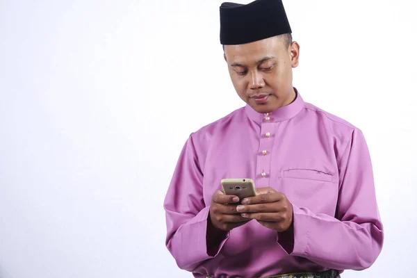 Człowiek w tradycyjne stroje ze smartfonem z okazji Eid al Fitr. — Zdjęcie stockowe