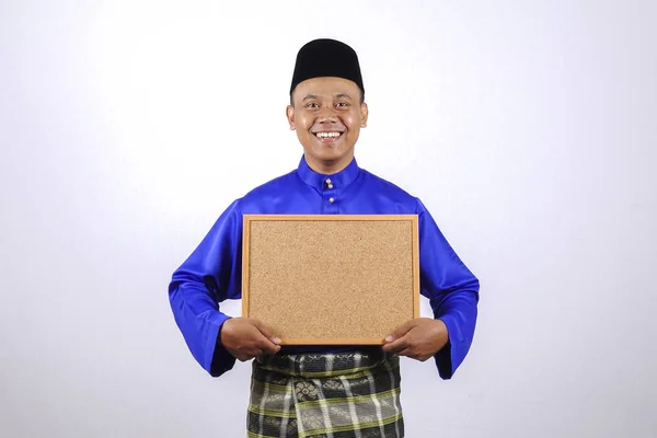Mladý muž s úsměvem s tabuli pro Eid Fitr Eid Adha, nebo oslavy. — Stock fotografie