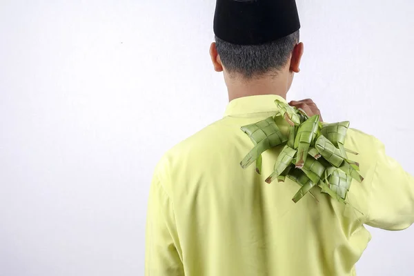 Jovem adulto muçulmano segurando bolinho de arroz durante Eid Mubarak . — Fotografia de Stock