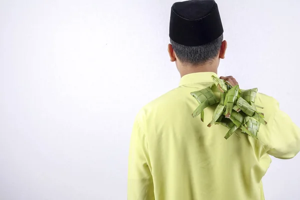 Jovem adulto muçulmano segurando bolinho de arroz durante Eid Mubarak . — Fotografia de Stock
