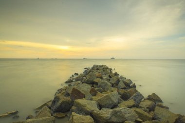 Scenery of sunset captured at Pantai Remis, Selangor, Malaysia. The motion of cloud and water is due to long exposure effect. Low light clipart