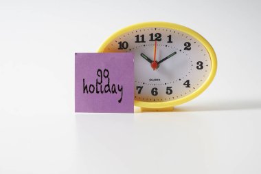 Zaman yönetimi kavramsal metin notu üzerinde sarı masa saati.