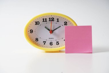 Zaman yönetimi kavramsal metin notu üzerinde sarı masa saati.