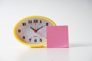 Zaman yönetimi kavramsal metin notu üzerinde sarı masa saati.