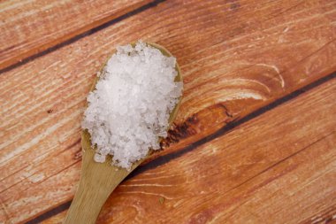 Bir tahta kaşık içinde deniz tuzu. Defne tuz olarak da adlandırılır veya güneş tuz, yemek ve kozmetik kullanılır. Kaba taneli mineral kristalleri.