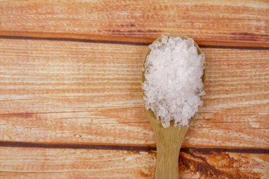 Bir tahta kaşık içinde deniz tuzu. Defne tuz olarak da adlandırılır veya güneş tuz, yemek ve kozmetik kullanılır. Kaba taneli mineral kristalleri.