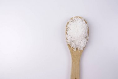 Bir tahta kaşık içinde deniz tuzu. Defne tuz olarak da adlandırılır veya güneş tuz, yemek ve kozmetik kullanılır. Kaba taneli mineral kristalleri.