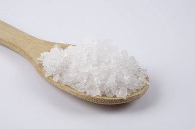 Bir tahta kaşık içinde deniz tuzu. Defne tuz olarak da adlandırılır veya güneş tuz, yemek ve kozmetik kullanılır. Kaba taneli mineral kristalleri.