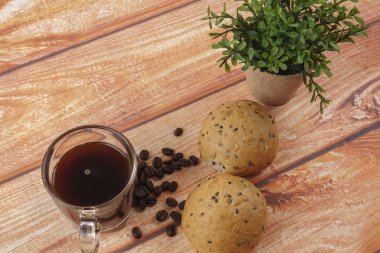 Sabah kahvaltı konseptiyle kahve, topuz, Mesaj ahşap arka plan üzerine notlar.