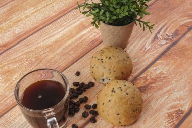 Sabah kahvaltı konseptiyle kahve, topuz, Mesaj ahşap arka plan üzerine notlar.