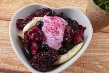 Yaban mersini, ahşap masa üzerinde chery ile dondurma kaşık toz.