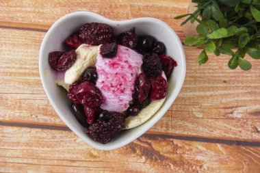 Yaban mersini, ahşap masa üzerinde chery ile dondurma kaşık toz.