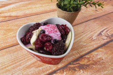 Yaban mersini, ahşap masa üzerinde chery ile dondurma kaşık toz.