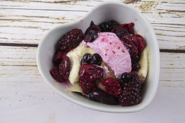 Yaban mersini, ahşap masa üzerinde chery ile dondurma kaşık toz.