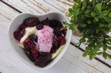 Yaban mersini, ahşap masa üzerinde chery ile dondurma kaşık toz.