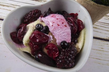 Yaban mersini, ahşap masa üzerinde chery ile dondurma kaşık toz.