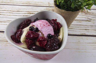 Yaban mersini, ahşap masa üzerinde chery ile dondurma kaşık toz.