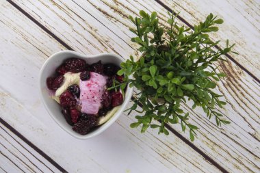 Yaban mersini, ahşap masa üzerinde chery ile dondurma kaşık toz.