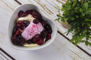 Yaban mersini, ahşap masa üzerinde chery ile dondurma kaşık toz.