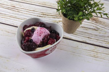 Yaban mersini, ahşap masa üzerinde chery ile dondurma kaşık toz.