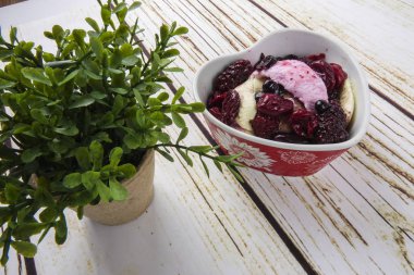 Yaban mersini, ahşap masa üzerinde chery ile dondurma kaşık toz.