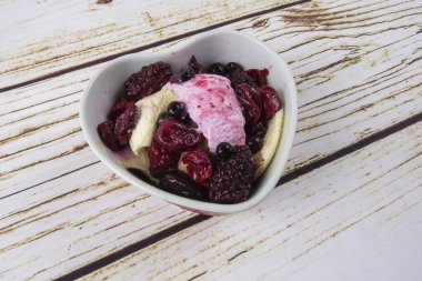 Yaban mersini, ahşap masa üzerinde chery ile dondurma kaşık toz.