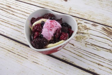 Yaban mersini, ahşap masa üzerinde chery ile dondurma kaşık toz.